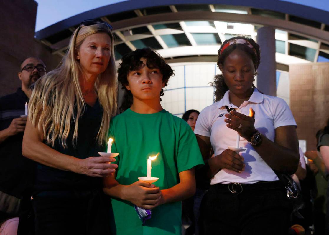 Leann Kramer, left, her son Kineau, 12, and Annet Sorongi, right, attend a prayer vigil for Hay ...