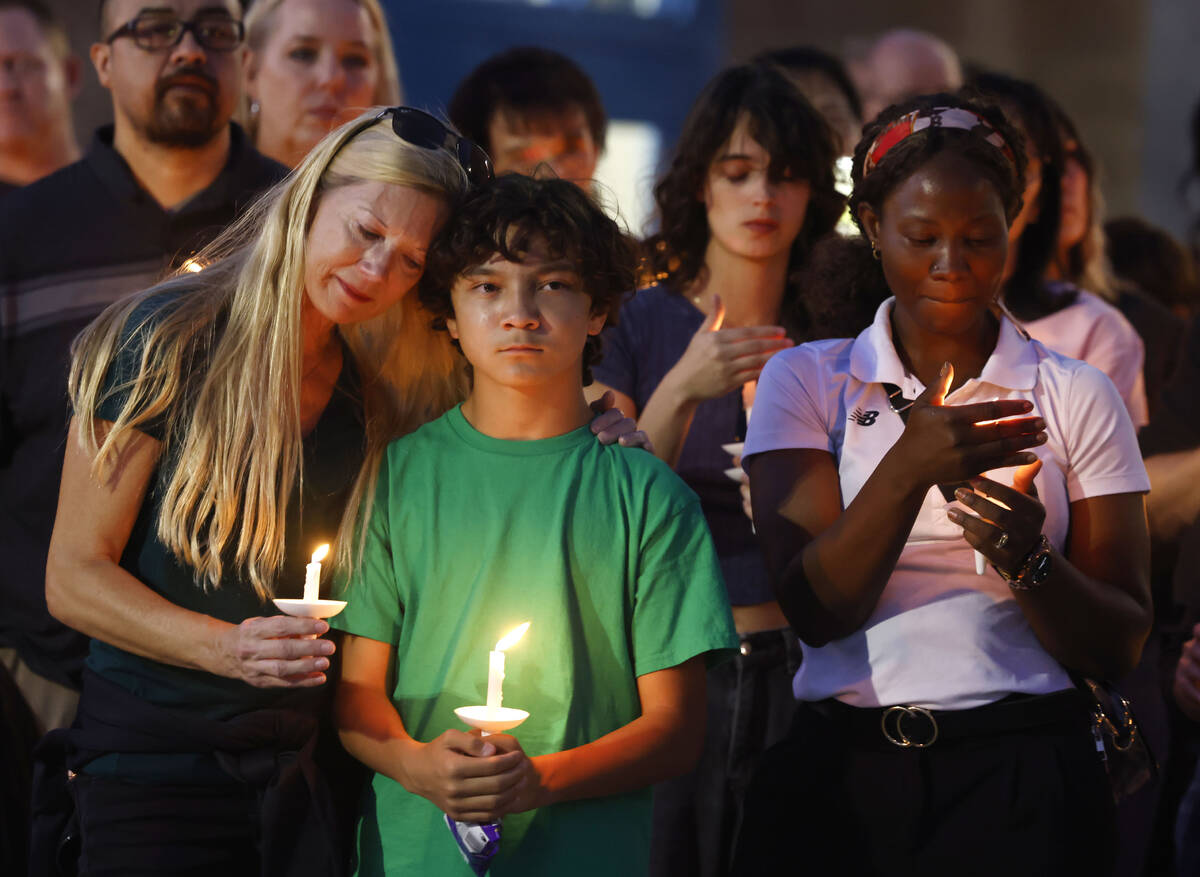 Leann Kramer, left, her son Kineau, 12, and Annet Sorongi, right, attend a prayer vigil for Hay ...