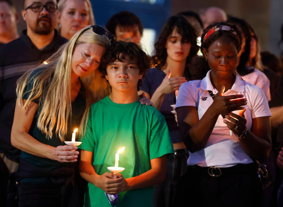 Leann Kramer, left, her son Kineau, 12, and Annet Sorongi, right, attend a prayer vigil for Hay ...