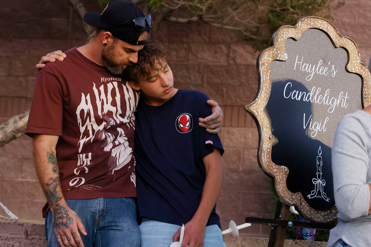 Taylor Ryan, the father of a crash victim Haylee, and his son Theodore, 13, attend a prayer vig ...