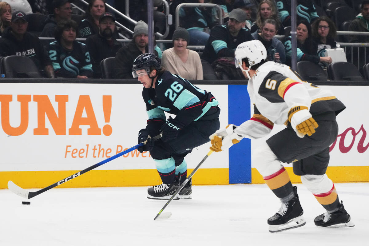 Seattle Kraken center Ryan Winterton (26) moves the puck past Vegas Golden Knights defenseman J ...
