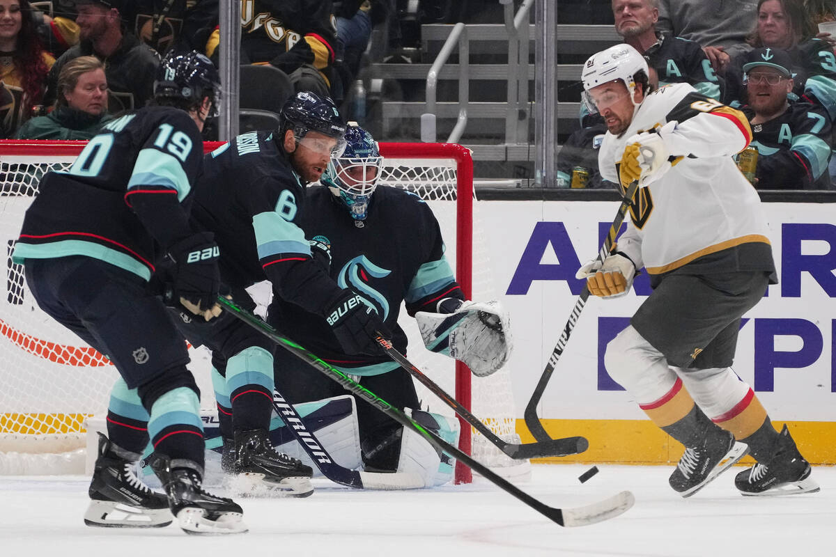 Vegas Golden Knights right wing Mark Stone, right, can't turn the puck for a clean shot on ...