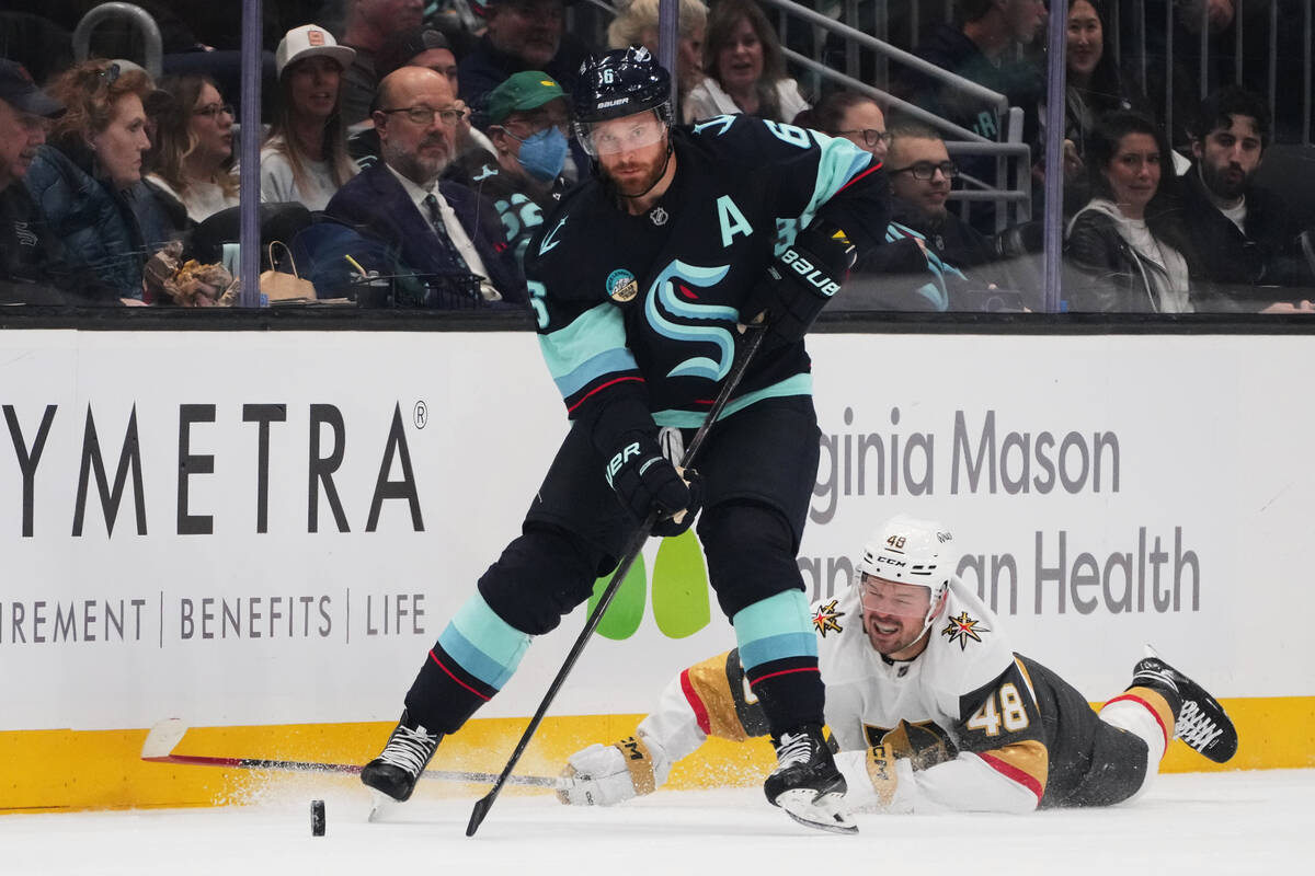 Seattle Kraken defenseman Adam Larsson (6) claims the puck from Vegas Golden Knights center Tom ...
