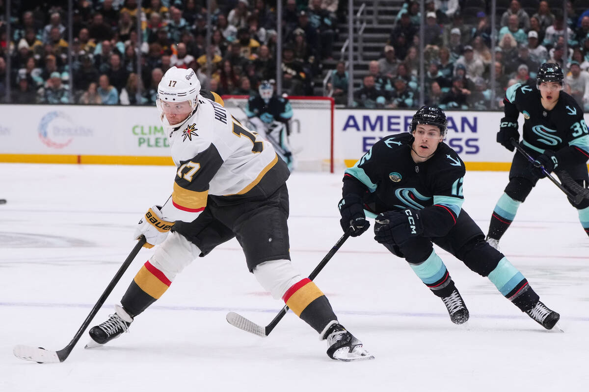 Vegas Golden Knights defenseman Ben Hutton (17) moves the puck away from Seattle Kraken left wi ...