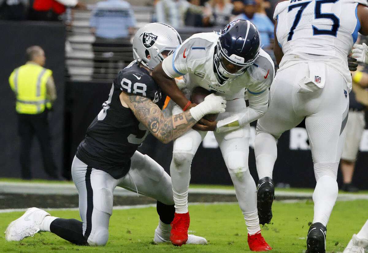 Raiders defensive end Maxx Crosby (98) sacks Tennessee Titans quarterback Cam Ward (1) during t ...