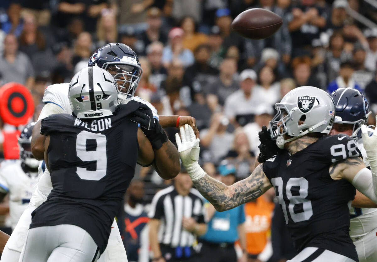 Tennessee Titans quarterback Cam Ward (1) throws a pass underpressure from Raiders defensive en ...