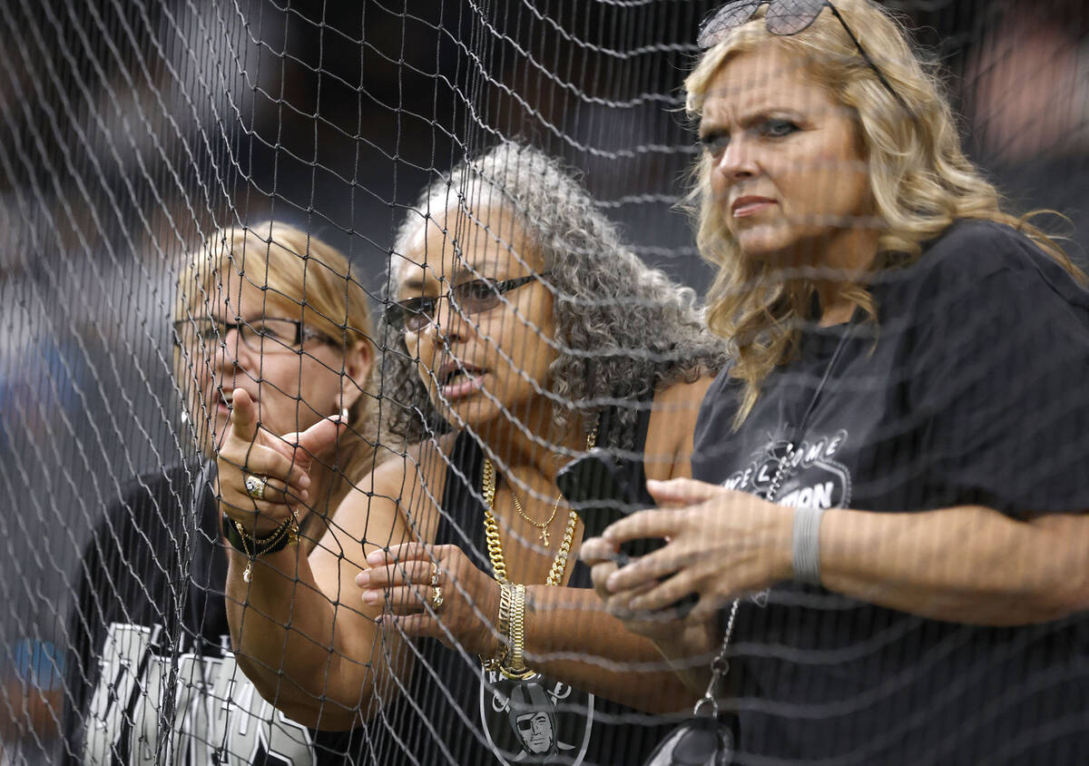 Raiders fans watch as players warm up before an NFL game to face Tennessee Titans at Allegiant ...