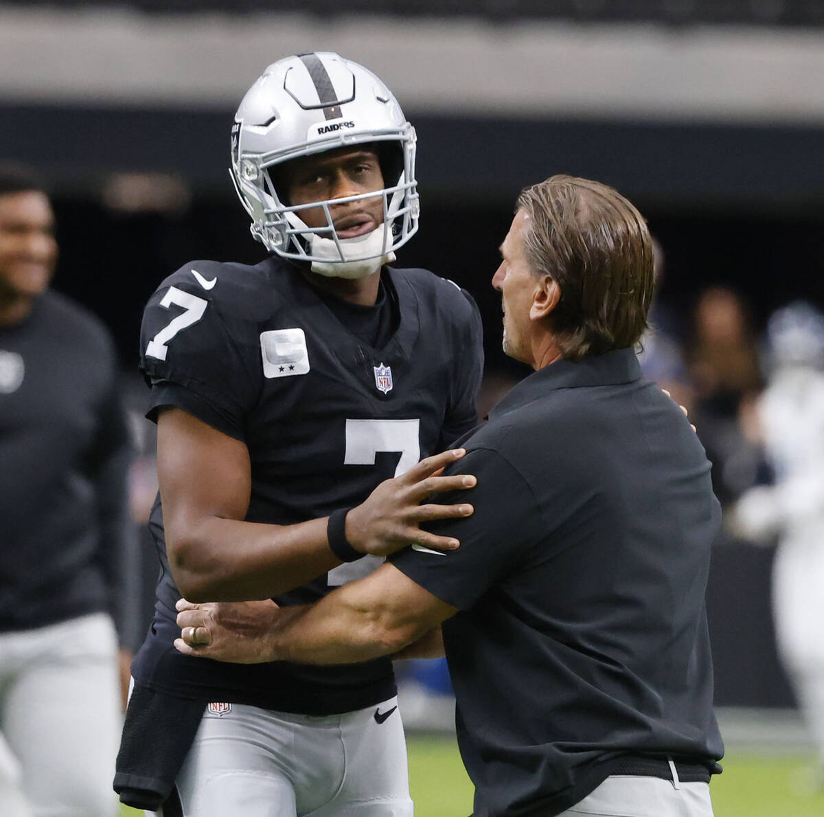 Raiders quarterbacks coach Greg Olson interacts with quarterback Geno Smith (7) before an NFL g ...