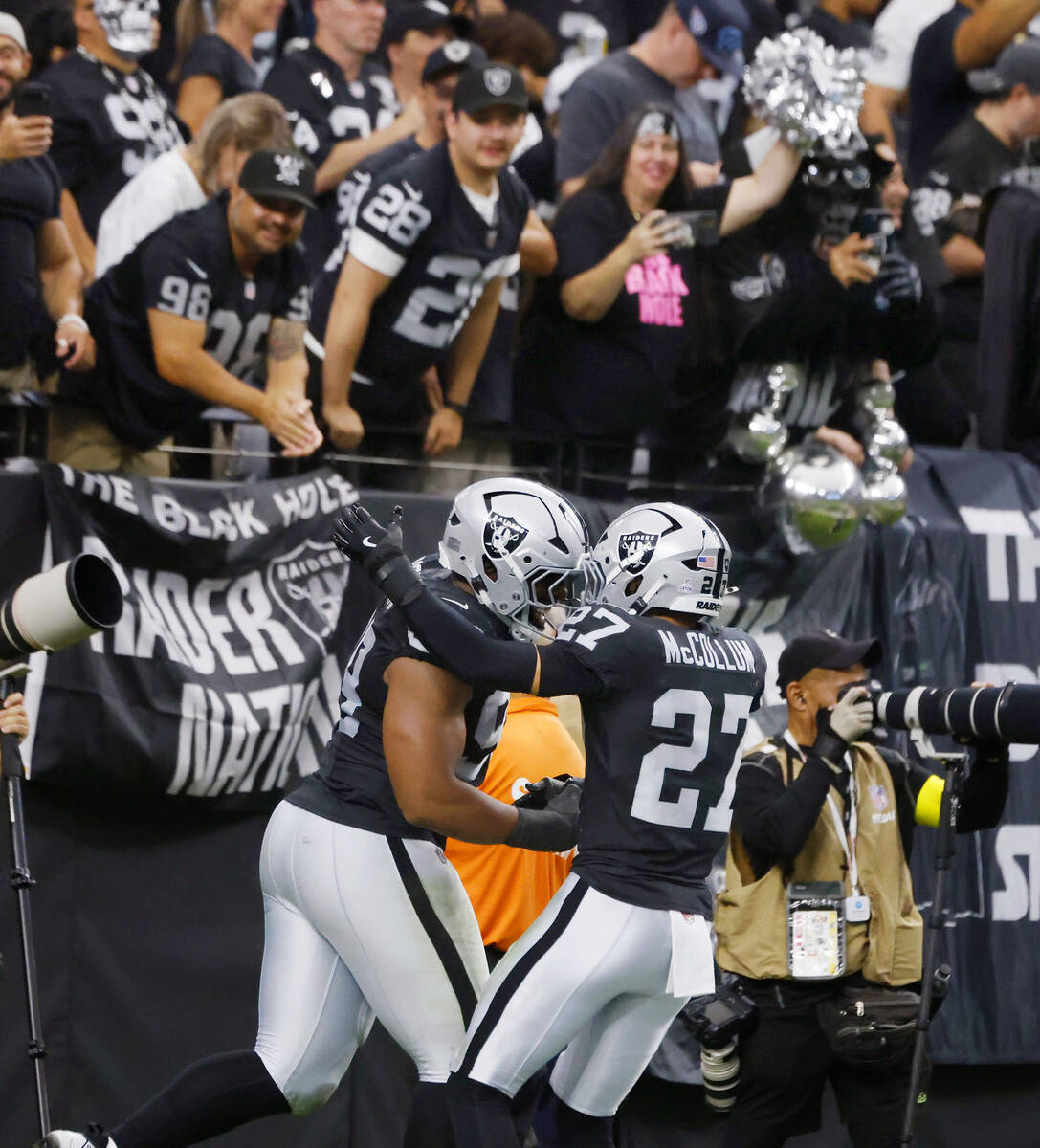 Raiders defensive tackle Thomas Booker (99) celebrates with safety Tristin McCollum (27) his fu ...