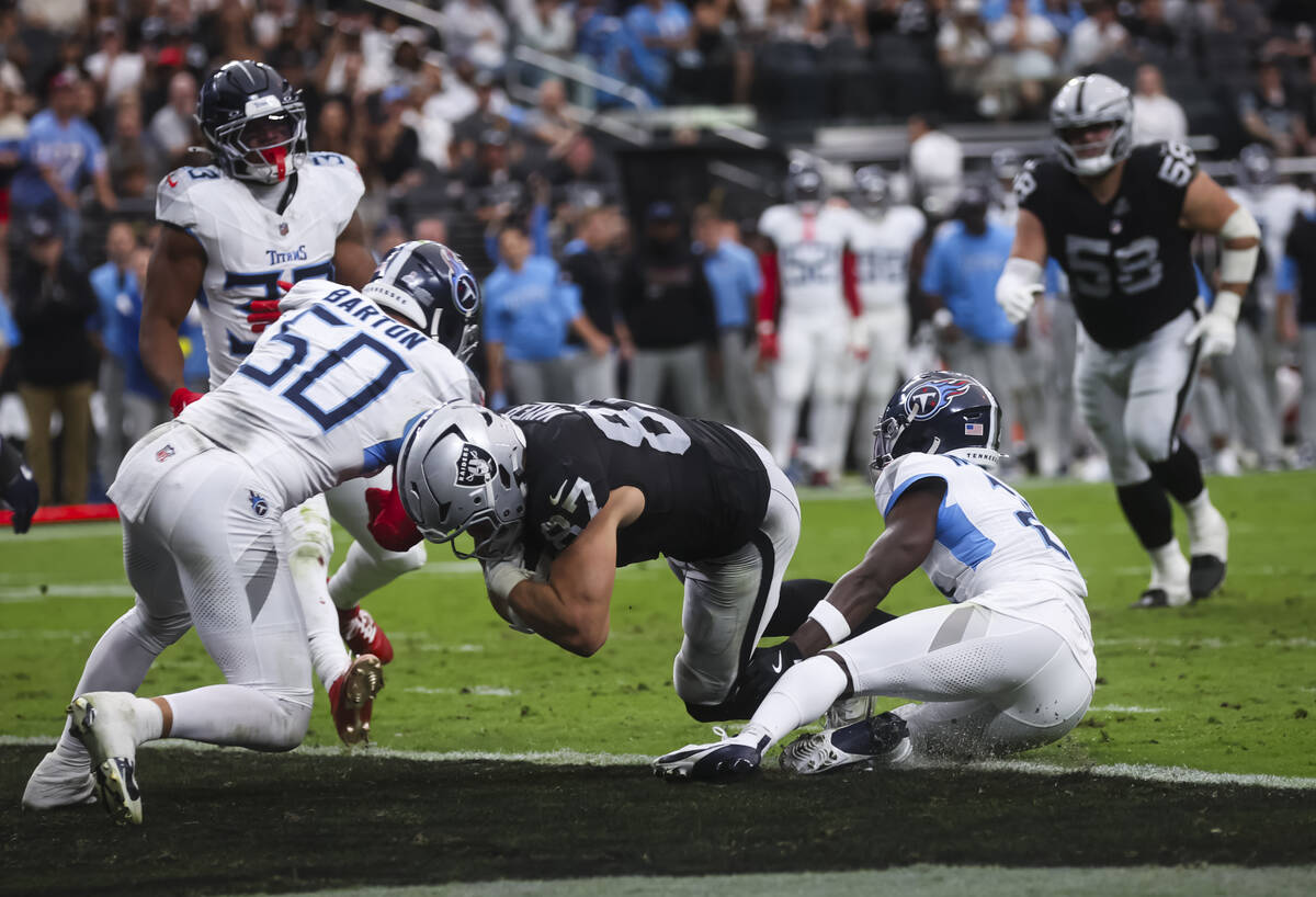 Raiders tight end Michael Mayer (87) dives between Tennessee Titans linebacker Cody Barton (50) ...