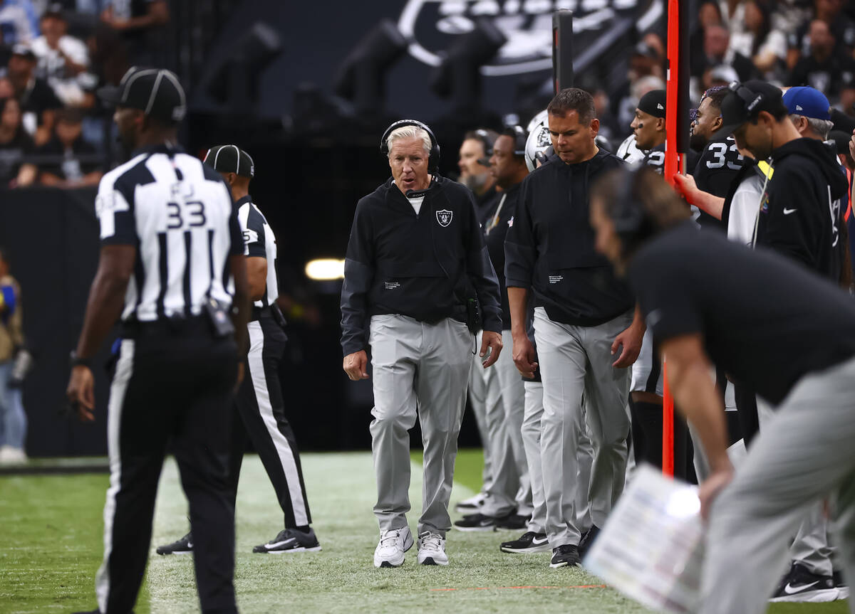 Raiders head coach Pete Carroll walks the sideline during the first half of an NFL game against ...