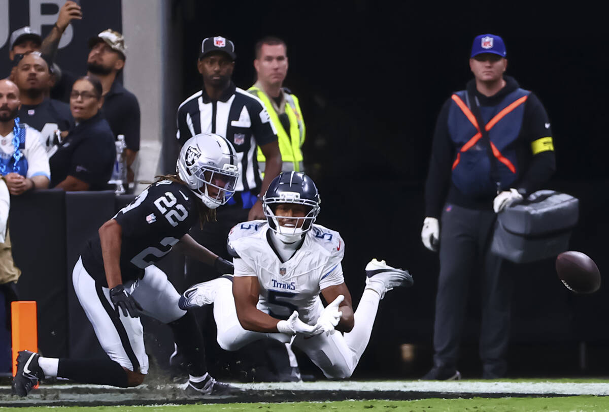 Tennessee Titans wide receiver Elic Ayomanor (5) misses the pass under pressure from Raiders co ...