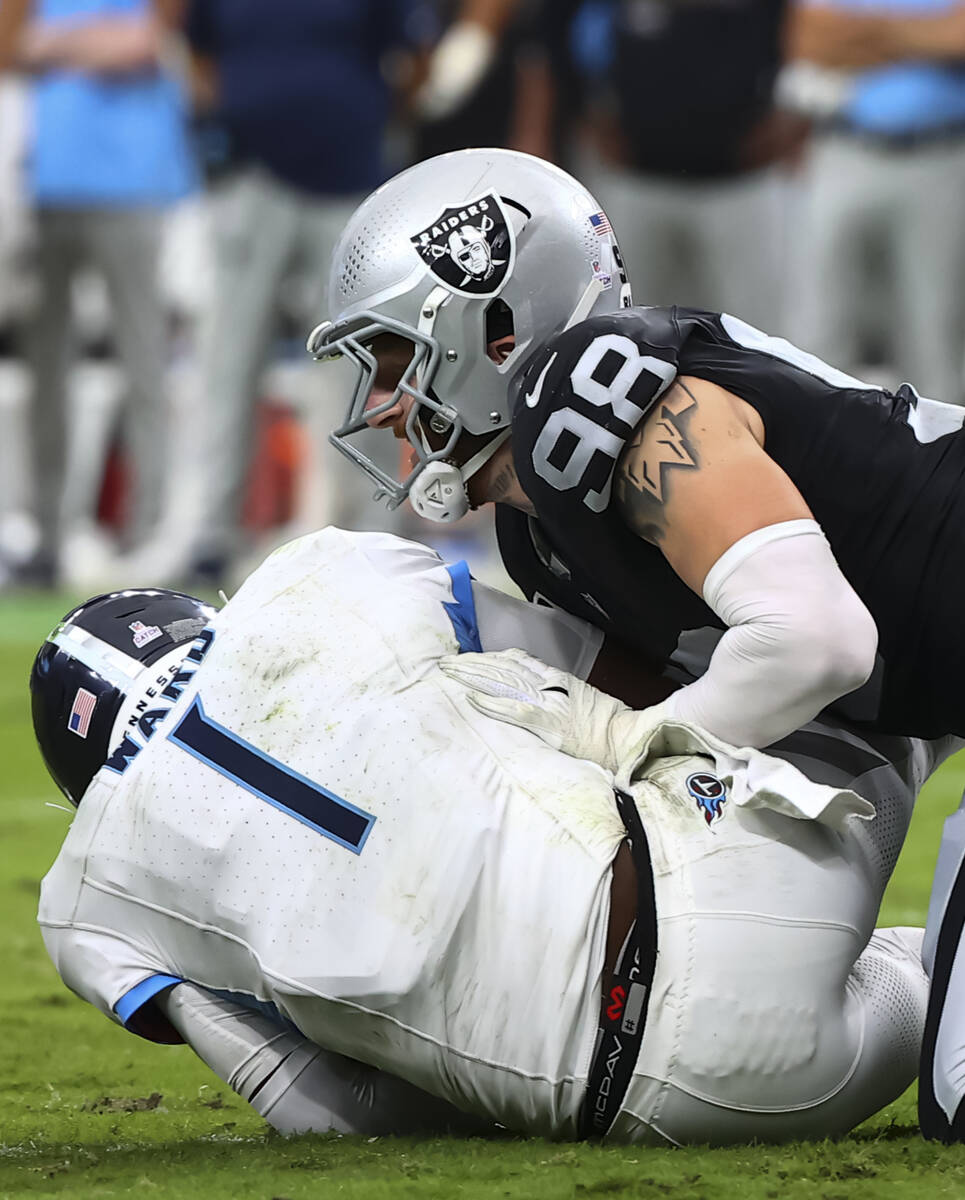 Raiders defensive end Maxx Crosby (98) sacks Tennessee Titans quarterback Cam Ward (1) during t ...