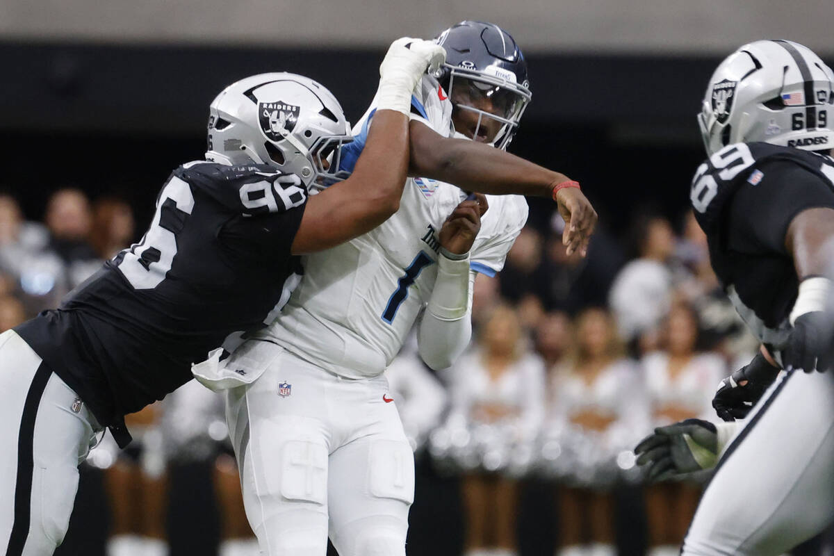 Tennessee Titans quarterback Cam Ward (1) throws a pass under pressure from Raiders defensive e ...