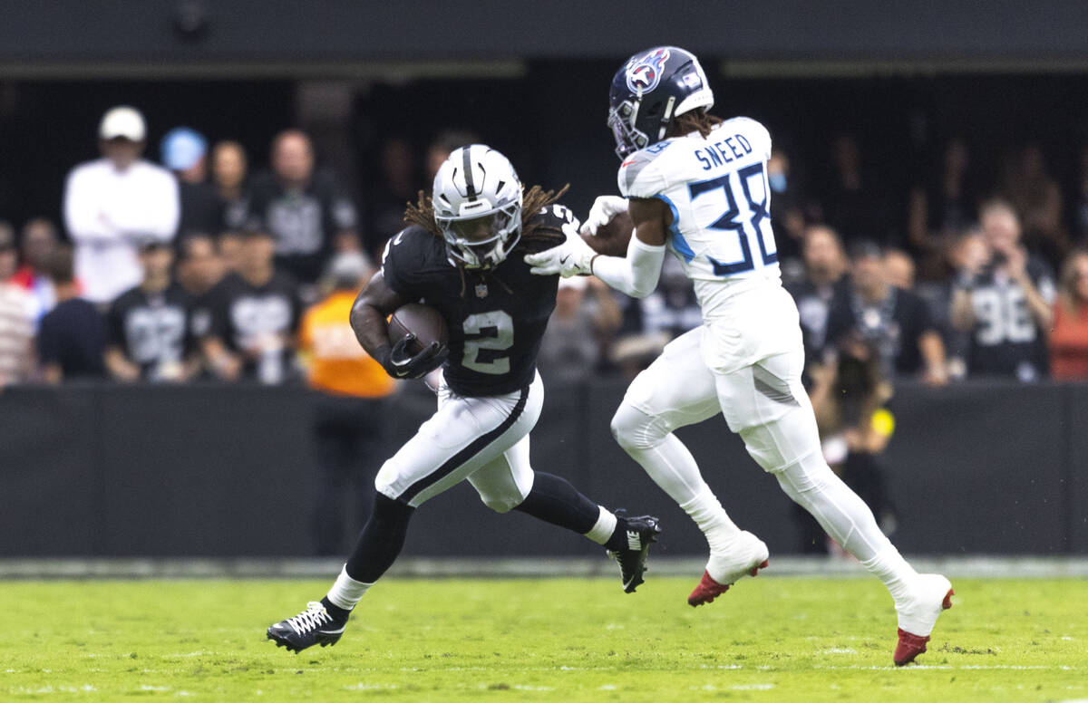 Raiders running back Ashton Jeanty (2) stiff arms Tennessee Titans cornerback L'Jarius Sne ...
