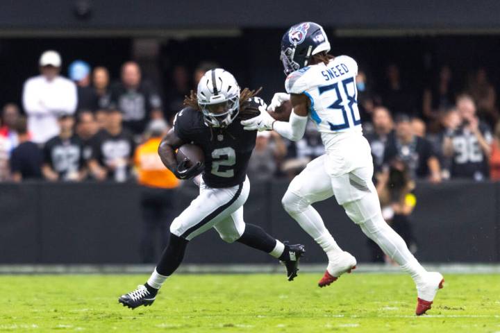 Raiders running back Ashton Jeanty (2) stiff arms Tennessee Titans cornerback L'Jarius Sne ...