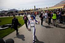 Driver Denny Hamlin makes his way to driver introductions before the start of the Pennzoil 400 ...