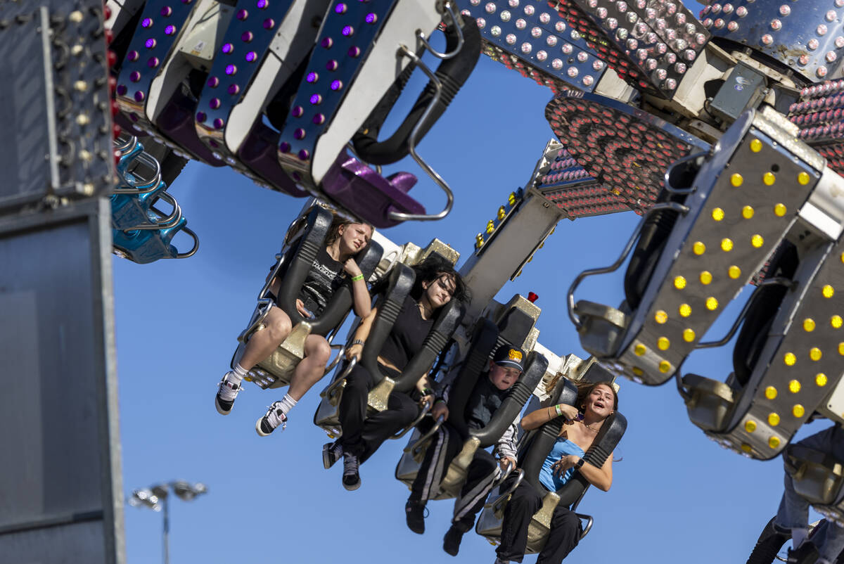 Race fans gets tossed about in a ride in the Fan Zone before the NASCAR Cup Series South Point ...