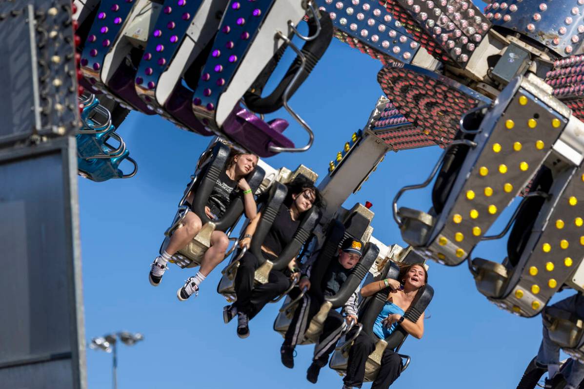 Race fans gets tossed about in a ride in the Fan Zone before the NASCAR Cup Series South Point ...