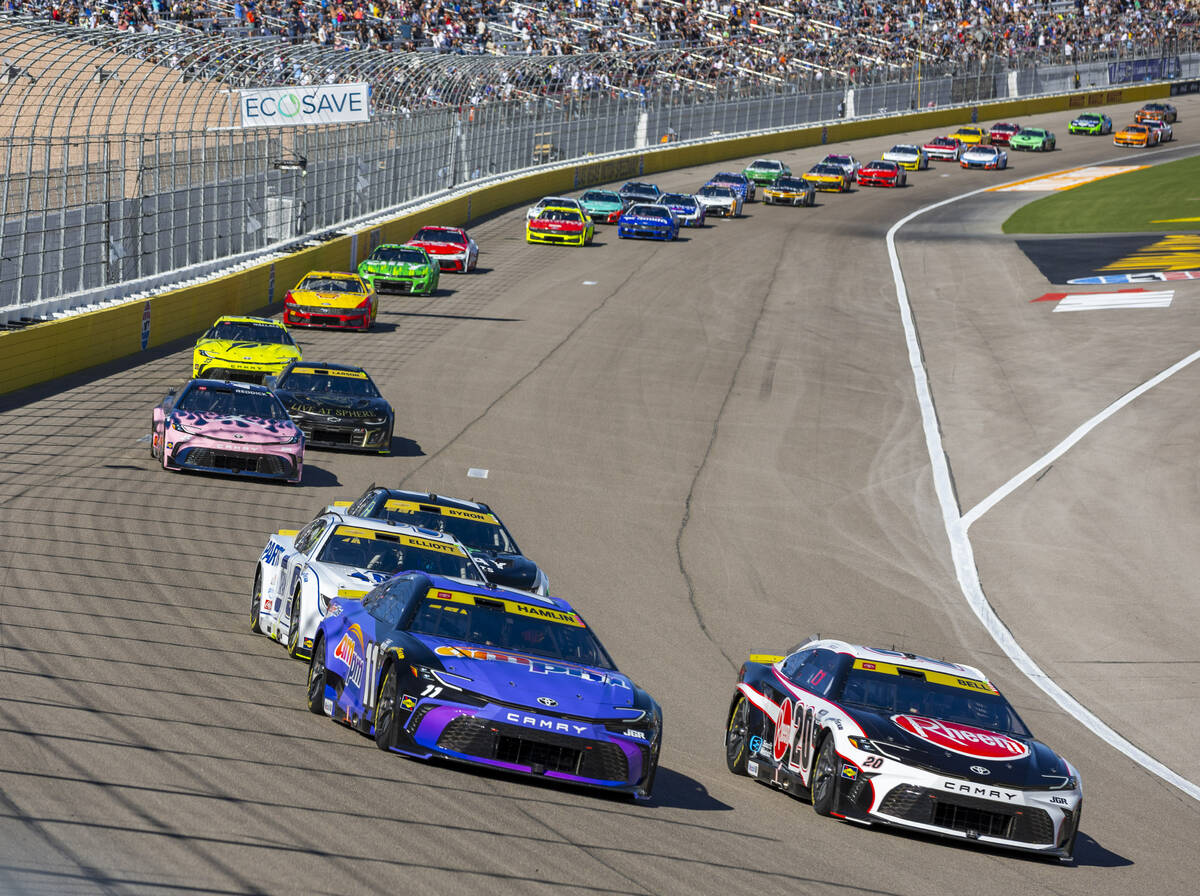 Denny Hamlin (11) races beside Christopher Bell (20) out of turn one early in the NASCAR Cup Se ...