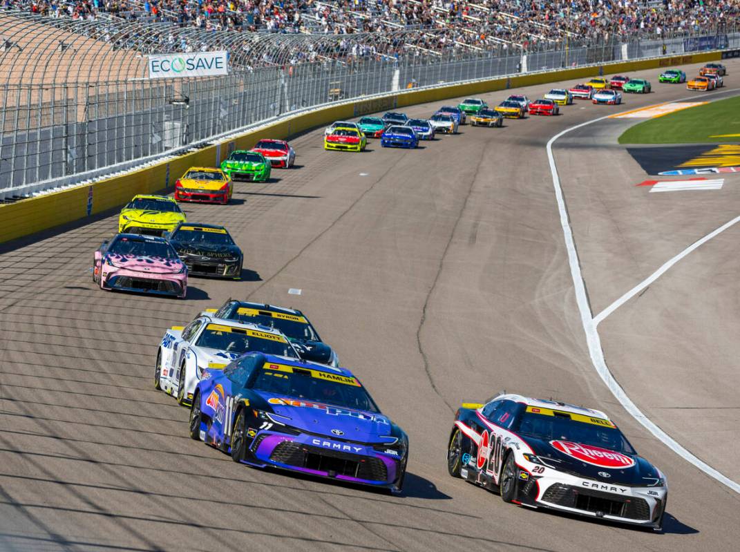 Denny Hamlin (11) races beside Christopher Bell (20) out of turn one early in the NASCAR Cup Se ...