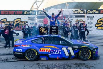 Denny Hamlin (11) celebrates with his team in victory lane after winning the NASCAR Cup Series ...