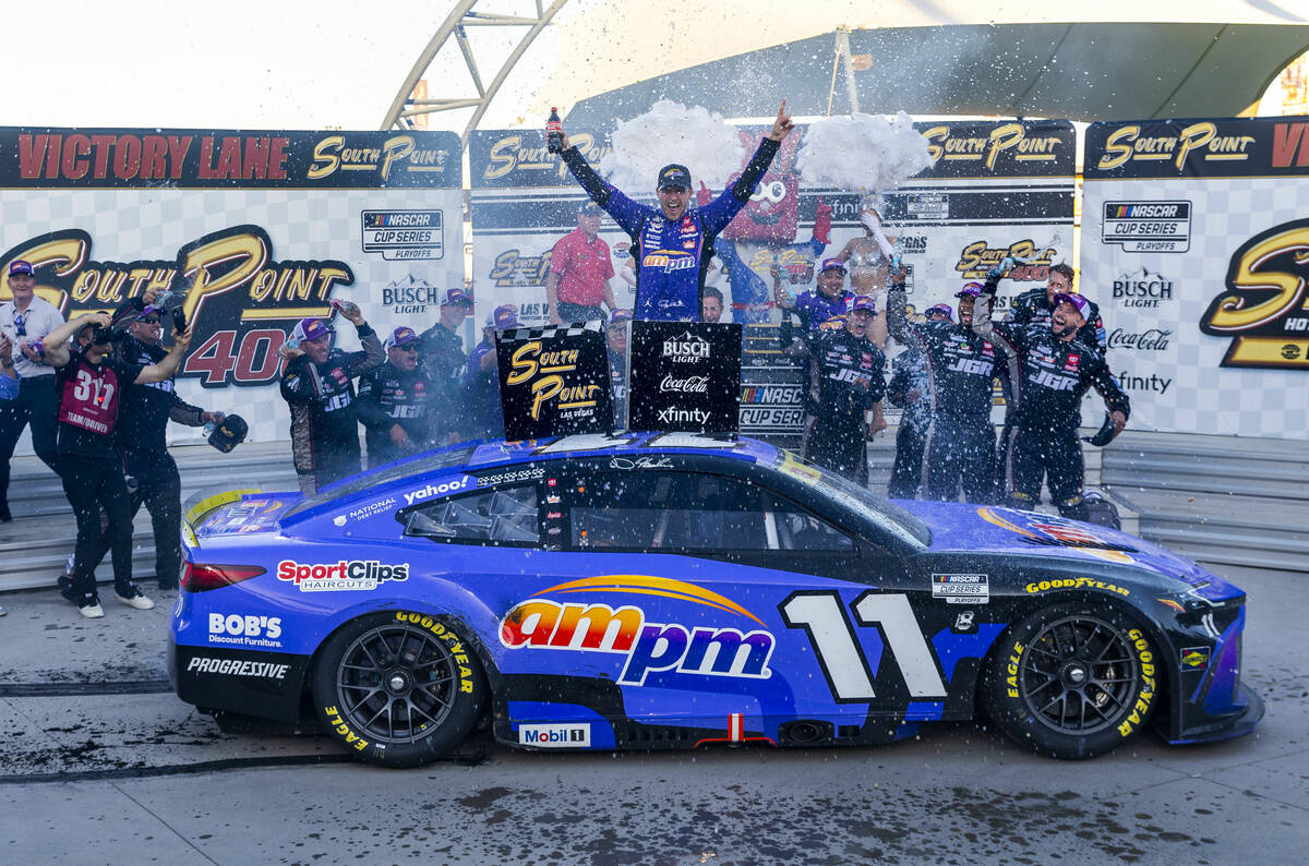 Denny Hamlin (11) celebrates with his team in victory lane after winning the NASCAR Cup Series ...
