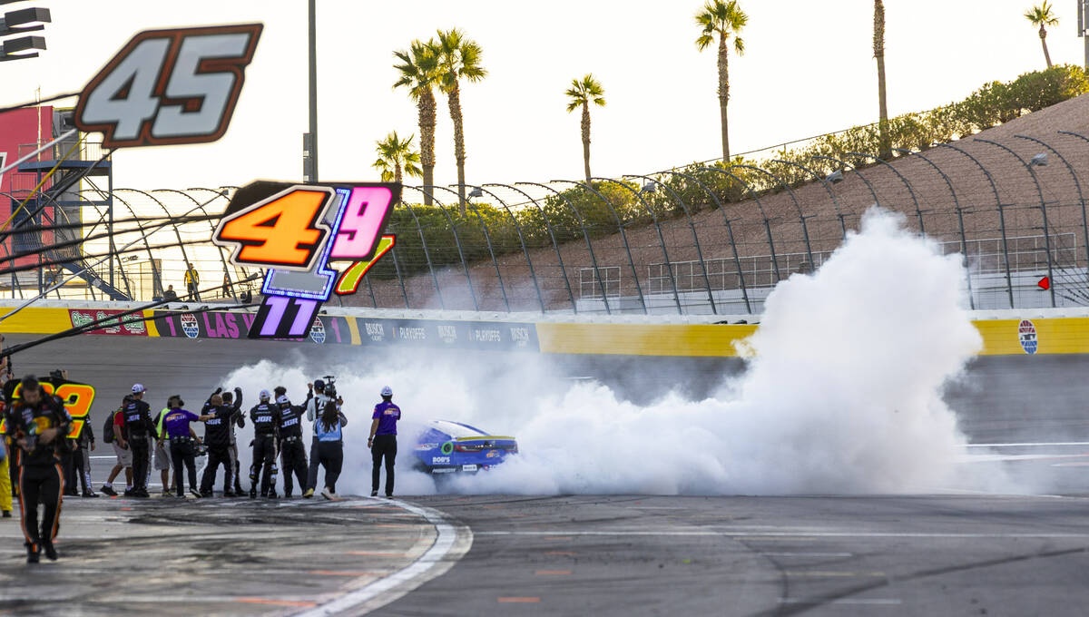 Denny Hamlin (11) burns out near his pit crew as they celebrate his win in the NASCAR Cup Serie ...
