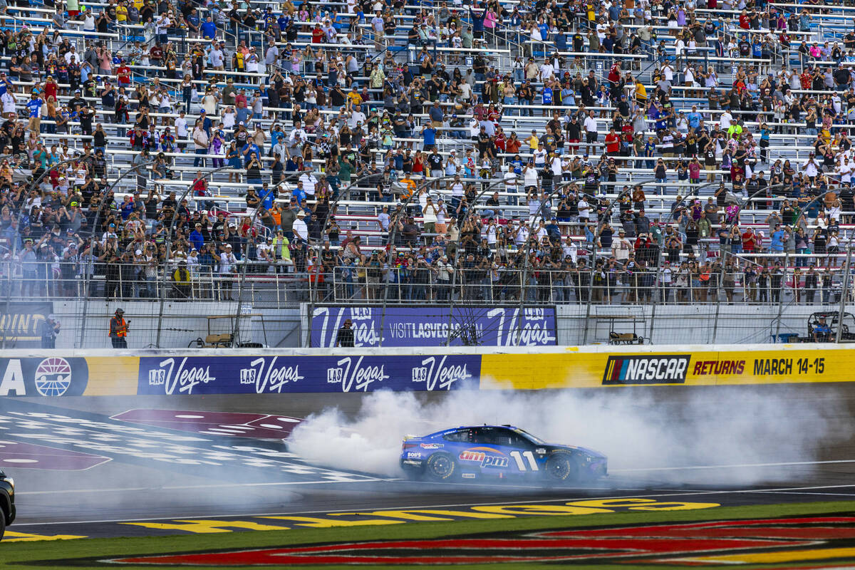 Denny Hamlin (11) burns out near the start/finish line to celebrate his win in the NASCAR Cup S ...