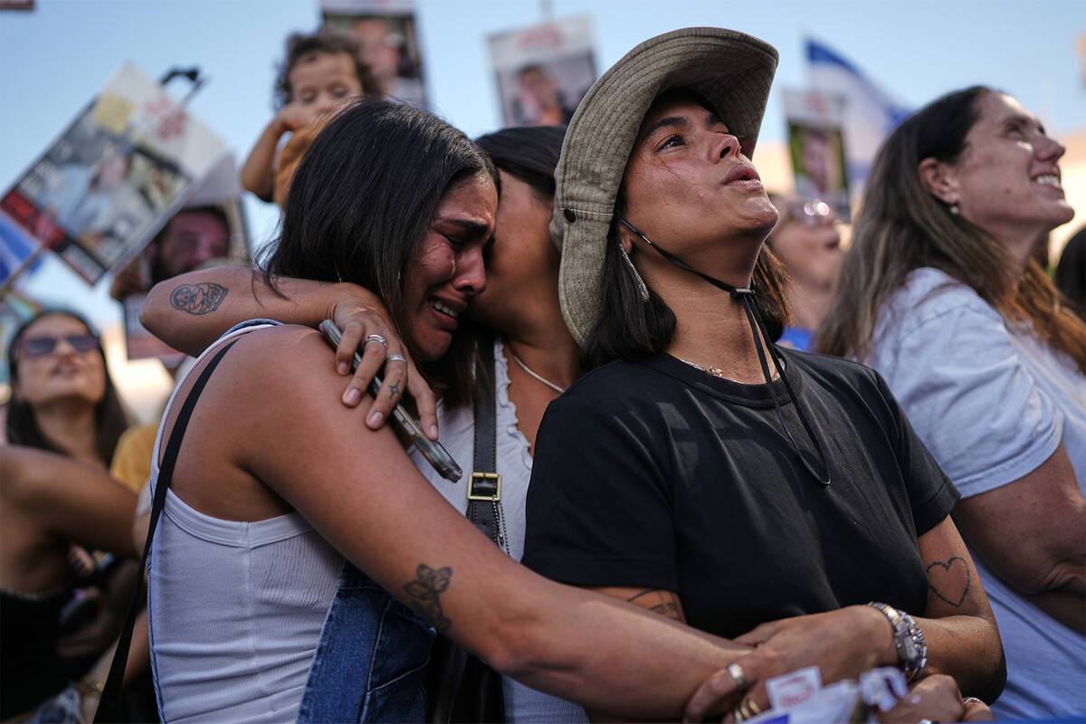 People react as they gather to watch a live broadcast of Israeli hostages released from Gaza at ...