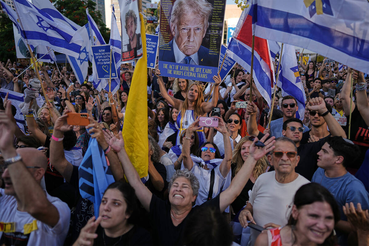 People react as they gather to watch a live broadcast of Israeli hostages released from Gaza at ...