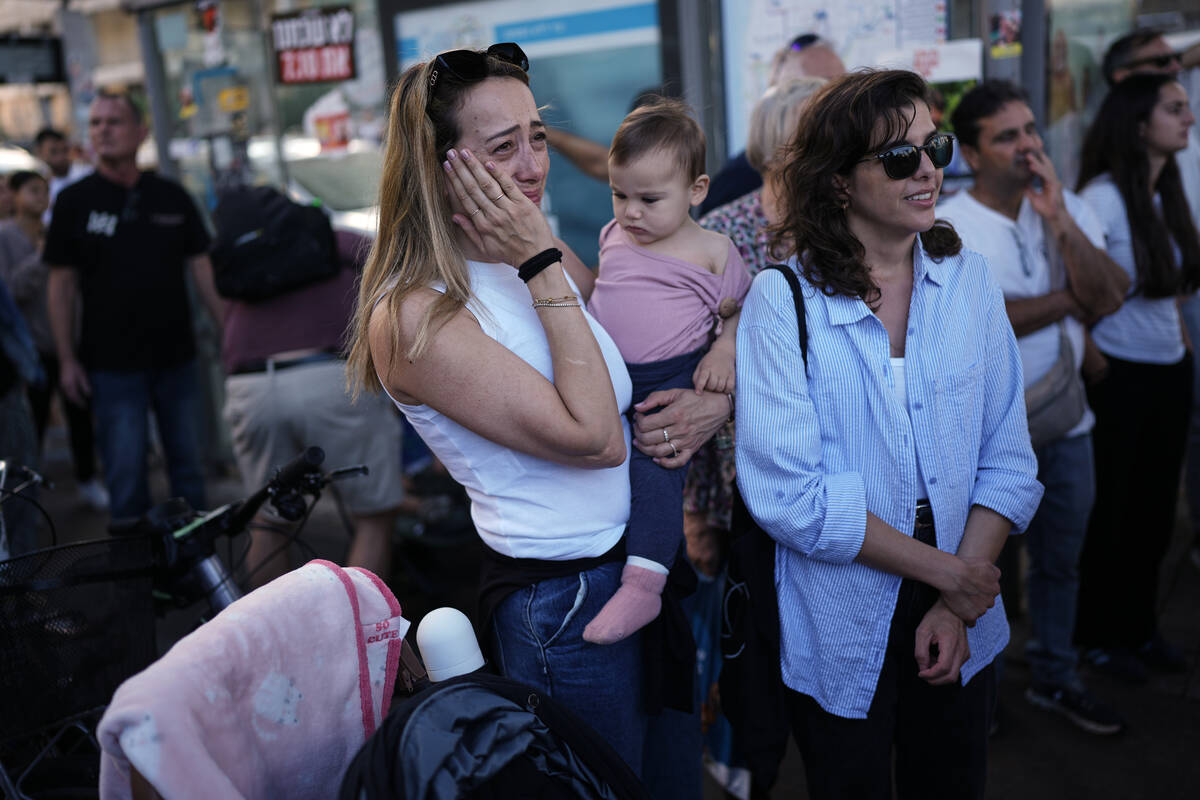 People react as they gather to watch a live broadcast of Israeli hostages released from Gaza at ...
