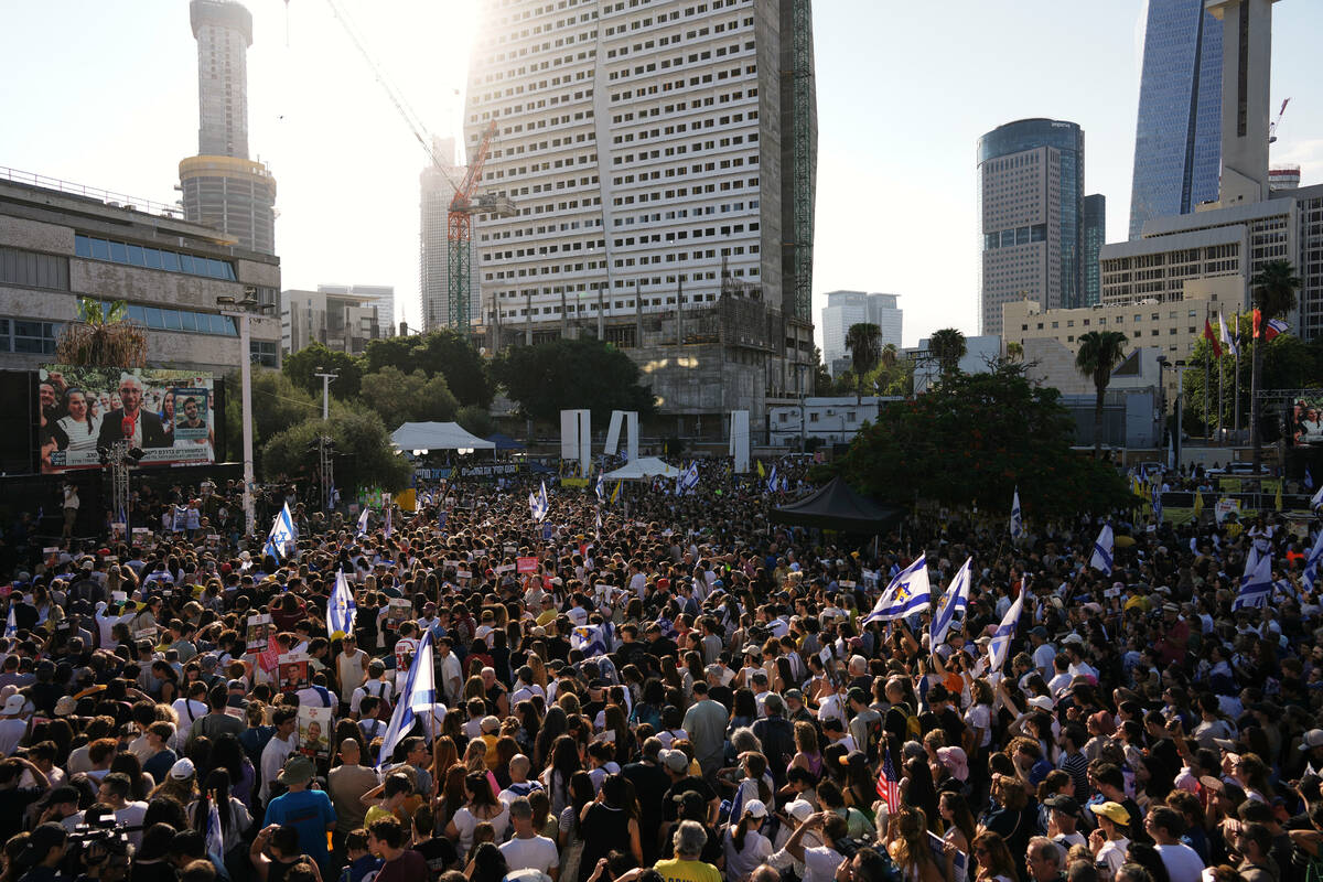 People gather to watch a live broadcast of Israeli hostages released from Gaza at a plaza known ...