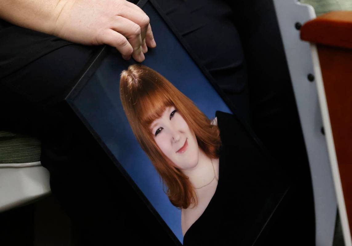 Tiffany Reynolds, holding a photograph of her daughter McKenzie Scott, attends a hearing for Ke ...