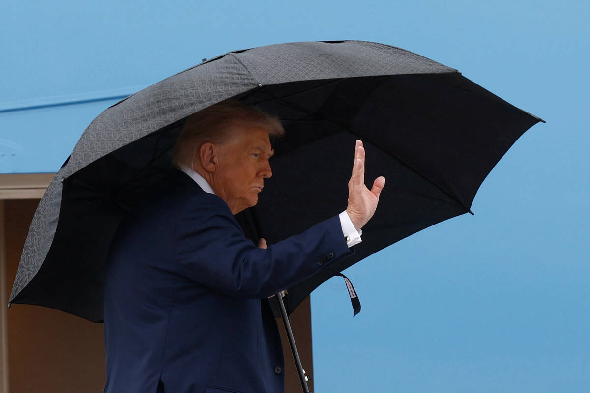 President Donald Trump waves from the stairs of Air Force One as he boards upon his arrival at ...