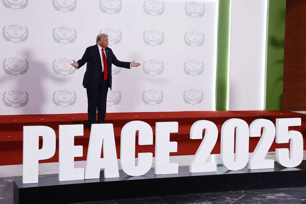 President Donald Trump gestures as he stands before a family picture during the greetings cerem ...