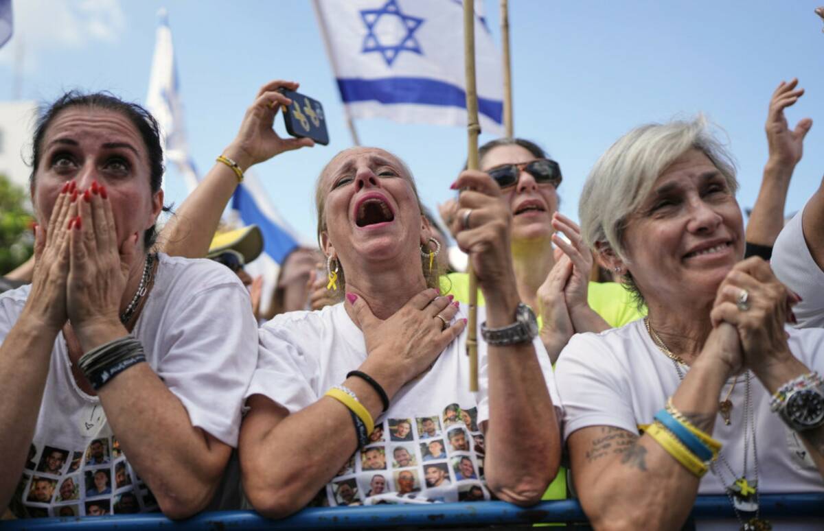 People react as they gather to watch a live broadcast of Israeli hostages released from Gaza at ...