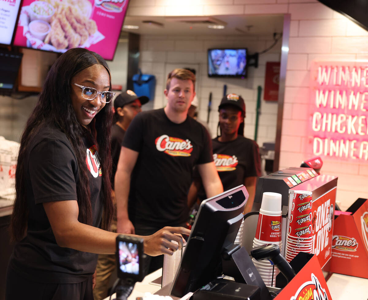 Aces guard Jackie Young gets ready to serve fans at Raising Cane’s on the Strip Tuesday, ...