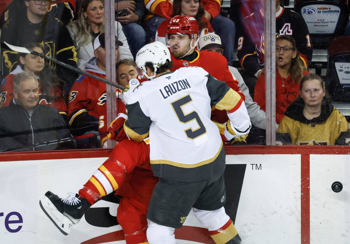 Vegas Golden Knights' Jeremy Lauzon, front, checks Calgary Flames' Adam Klapka during ...