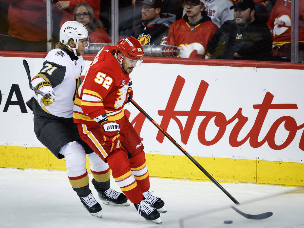 Vegas Golden Knights' William Karlsson, left, checks Calgary Flames' MacKenzie Weegar during fi ...