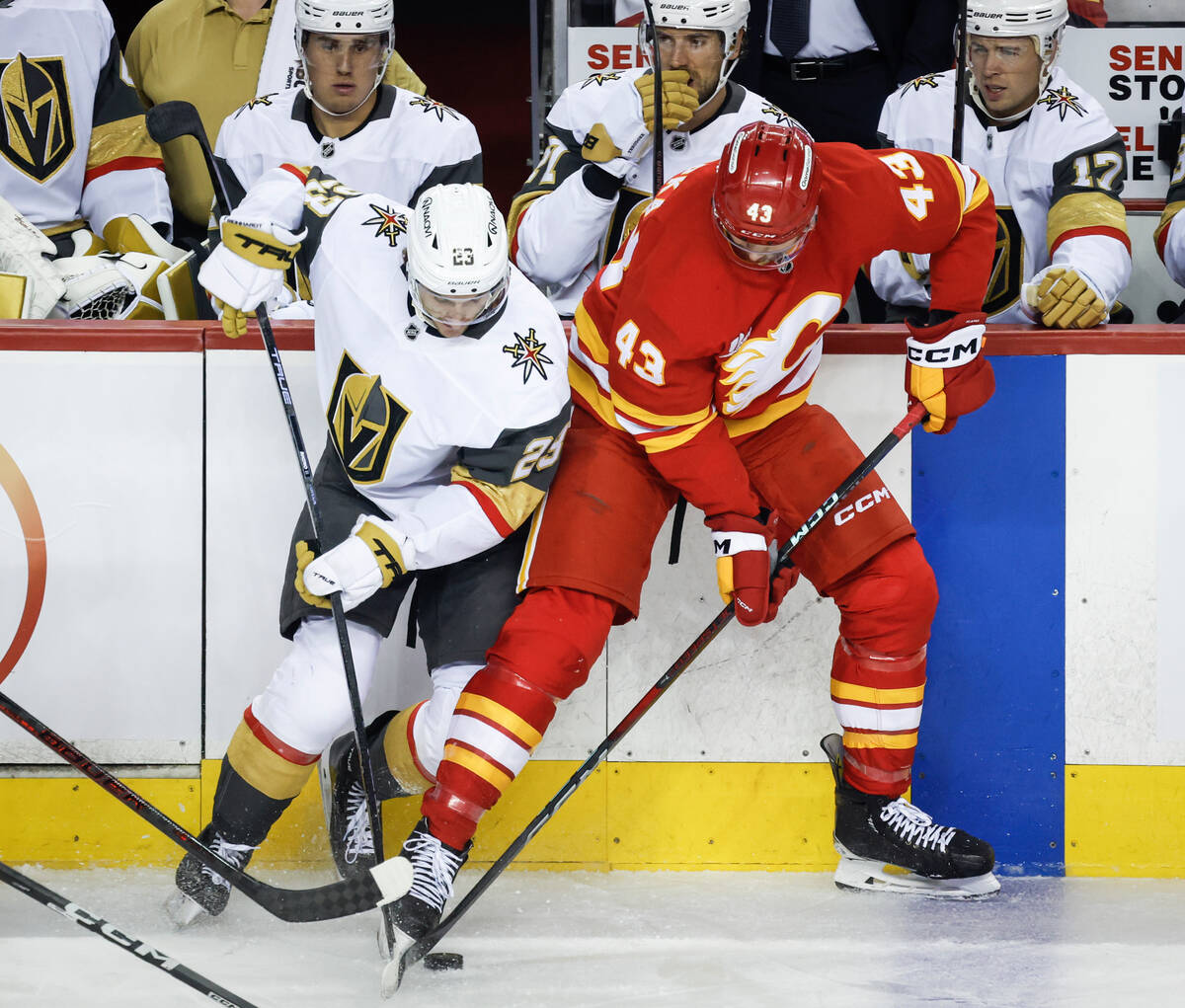 Vegas Golden Knights' Cole Reinhardt, left, and Calgary Flames' Adam Klapka battle for the puck ...