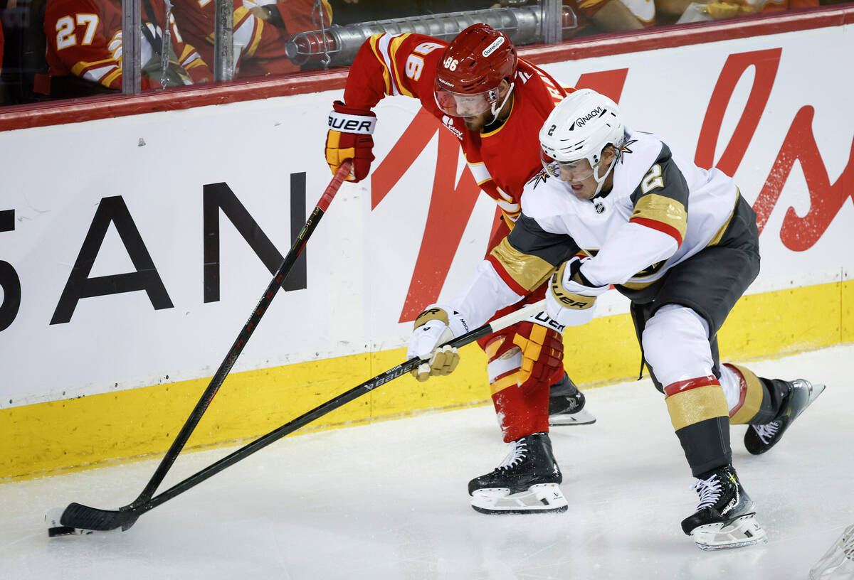 Vegas Golden Knights' Zach Whitecloud, right, and Calgary Flames' Joel Farabee battle ...