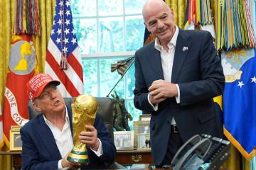 FILE - President Donald Trump holds the FIFA World Cup Winners Trophy as FIFA President Gianni ...
