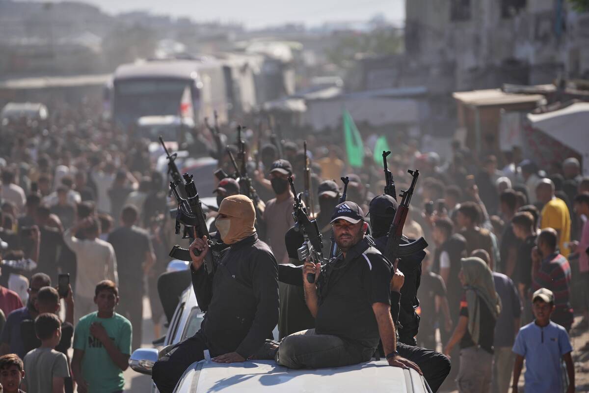 Hamas gunmen on pickup trucks escort buses carrying freed Palestinian prisoners as they are gre ...