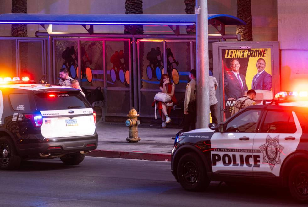 Metropolitan Police Department officers detain a man by a bus stop off Flamingo Road, outside o ...