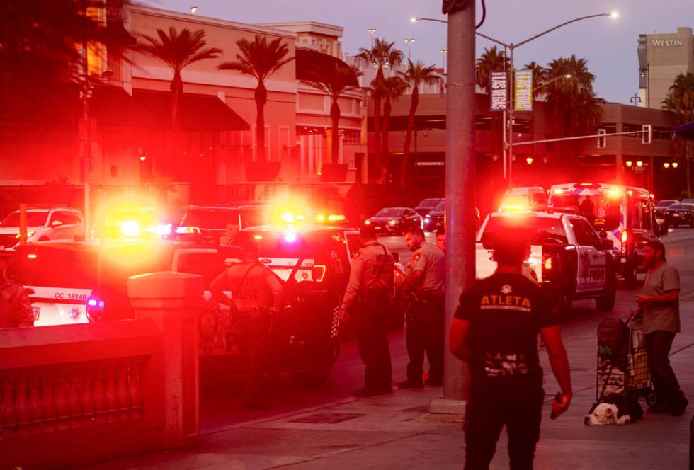 Metropolitan Police Department officers detain a man by a bus stop off Flamingo Road, outside o ...