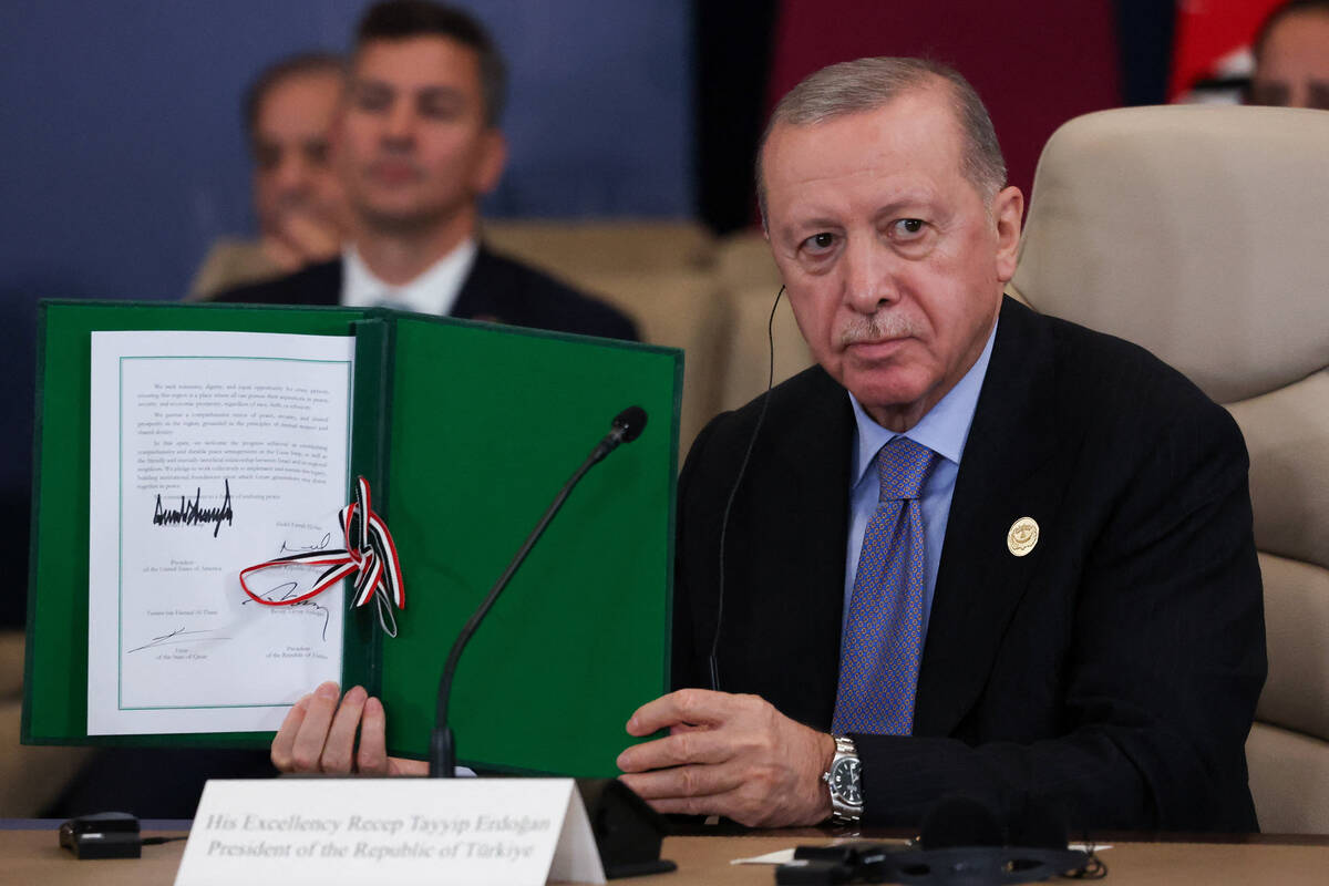 Turkey's President Recep Tayyip Erdogan holds a signed document during a summit to support ...