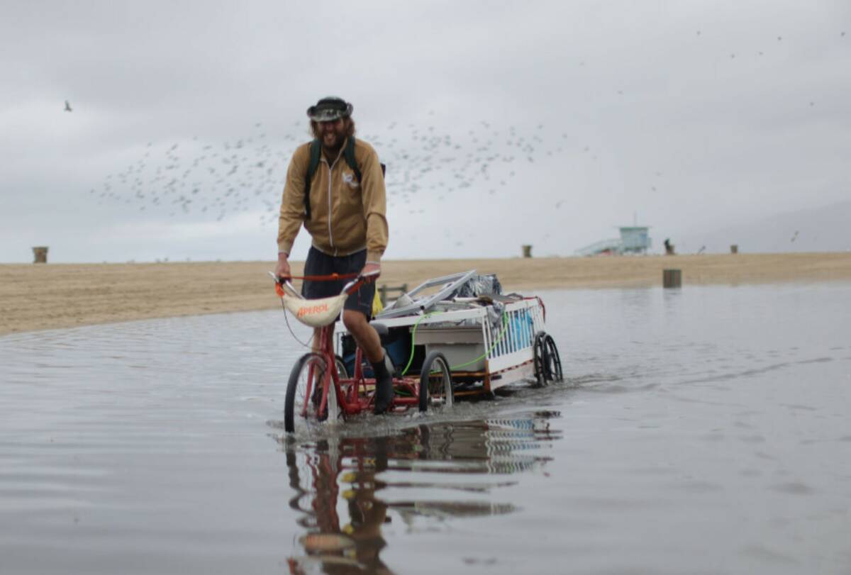 A man bikes along a flooded path after heavy rains Tuesday, Oct. 14, 2025, in Santa Monica, Cal ...