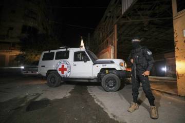 A gunman wearing the uniform of the al-Qassam Brigades, the military wing of Hamas, stands guar ...