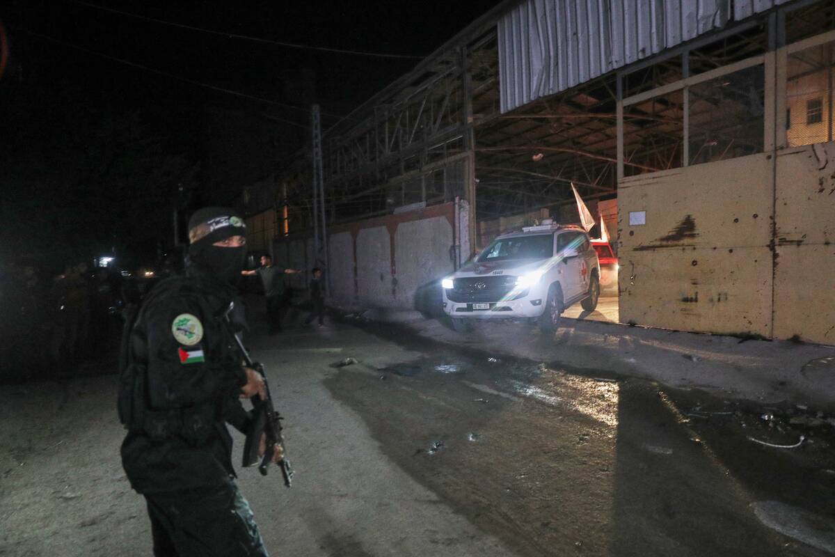 A gunman wearing the uniform of the al-Qassam Brigades, the military wing of Hamas, stands guar ...